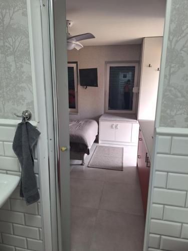 a small room with a bed and a bathroom at Domek Za Wyspą 3 in Chmielów