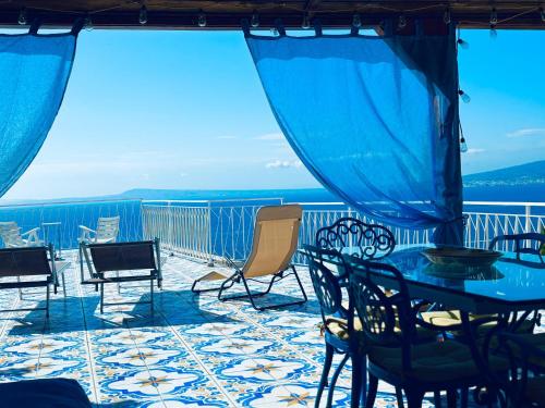 a patio with a table and chairs on a balcony at The Dreamer's Terrace in Vico Equense