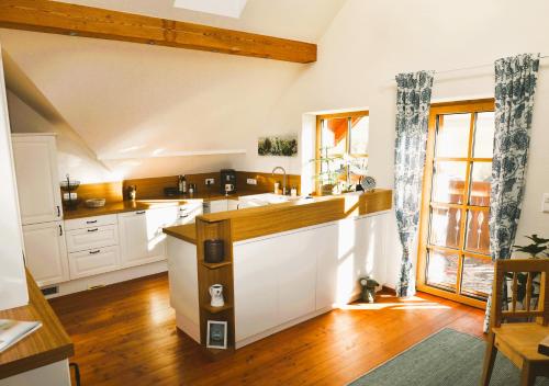 a kitchen with white cabinets and a large window at Honigduft und Bienenluft in Sankt Oswald bei Freistadt