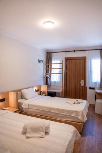 a hotel room with two beds and a desk at Sunmed Lodge in Oludeniz