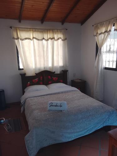 a bedroom with a bed with a sign on it at Hostal familiar Shambala in Silos