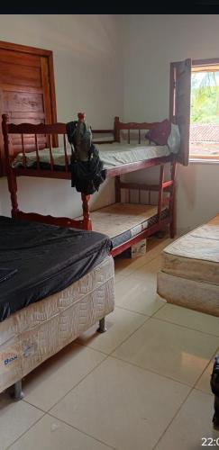 a room with three bunk beds and a window at Hospedagem da Paty in Ilhéus