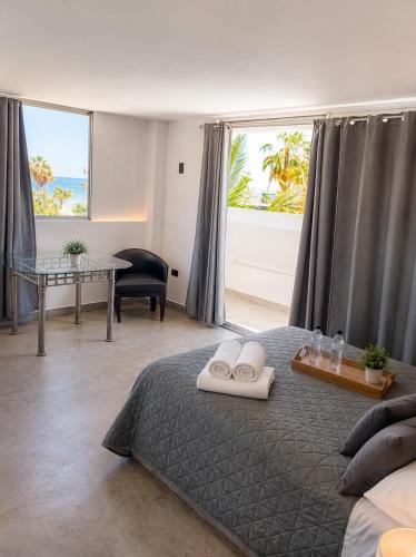 a bedroom with a bed and a table and a window at Hotel Miramar - La Paz in La Paz