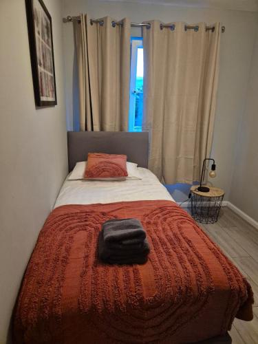 a bedroom with a bed with a red blanket and a window at Bellfield Views in Dundee
