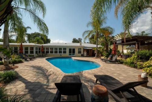 a swimming pool with chairs and a building at The Poolside Studio - Lounge Pool Wifi in Jacksonville
