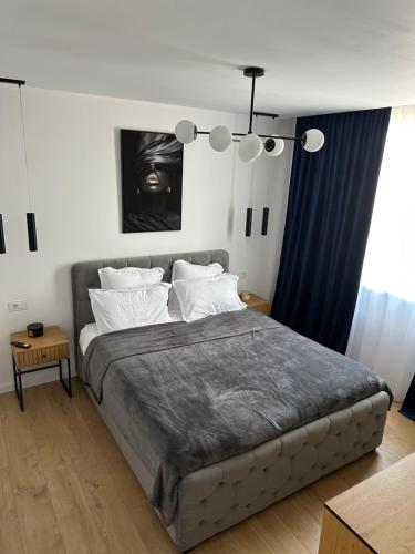 a bedroom with a large bed with blue curtains at Paradise Relax in Zalău
