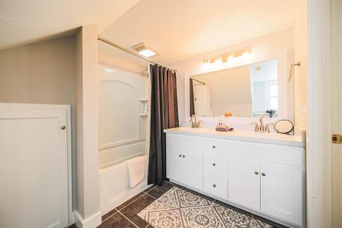 a bathroom with a sink and a large mirror at The Berlin Guesthouse in Millersburg