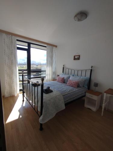 a bedroom with a bed and a large window at Mountain Nest Pirin in Razlog