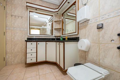 a bathroom with a toilet and a sink and a mirror at Sottam Hostel in Curitiba