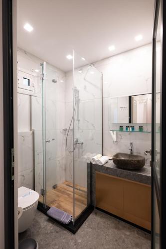 a bathroom with a shower and a sink and a toilet at Double M Adults Only in Ano Mera