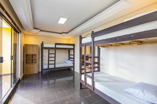a dorm room with three bunk beds in it at Sottam Hostel in Curitiba