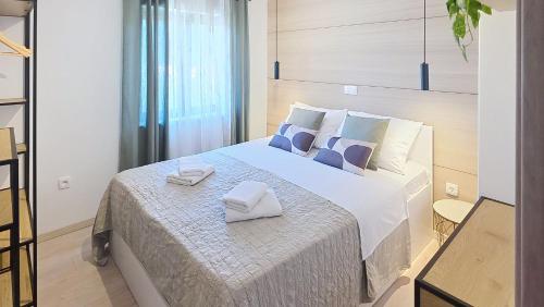 a bedroom with a large bed with towels on it at Apartments Grozdana in Baška