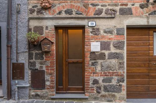 a brick building with a door with a sign on it at La Casetta dei Forni in Radicofani