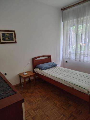 a small bedroom with a bed and a window at la casa rosa in Breguzzo