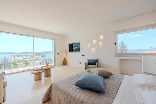 a bedroom with a large bed and large windows at Antares Rooms and Suites in Olbia