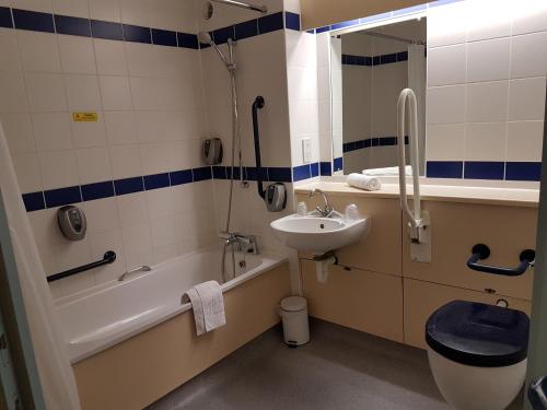 a bathroom with a sink and a tub and a toilet at Days Inn Sutton Scotney North in Sutton Scotney
