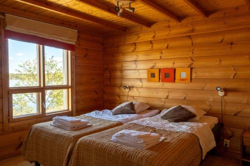 a bedroom with two beds in a log cabin at Oravi Villa 1 Teeri in Savonlinna