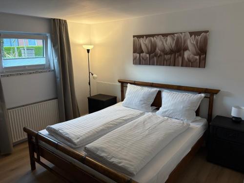 a bedroom with a bed with white sheets and a window at Ferienwohnung am Ith in Eschershausen