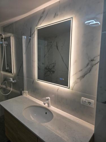 a bathroom with a sink and a mirror at Sky luxury apartment in Giurgiu