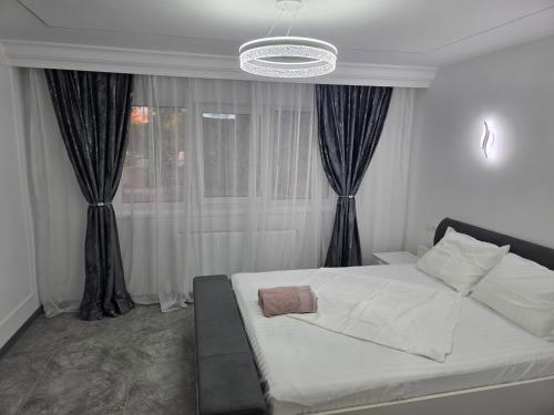 a bedroom with a white bed and a window at Sky luxury apartment in Giurgiu
