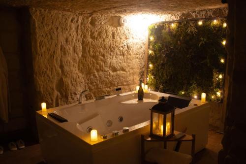 a bathroom with a tub with candles and lights at Lantray Secrète in Les-Trois-Moutiers