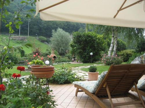 a patio with a chair and flowers and an umbrella at Hotel Calvi-Ristorante Mainor in Vittorio Veneto