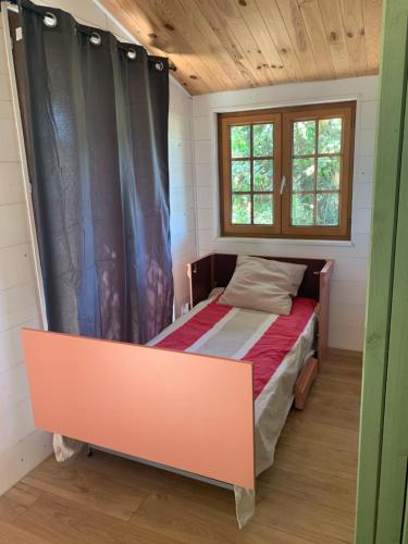 a small bedroom with a bed and a window at Chalet bucolique in Saint-Étienne-de-Chigny