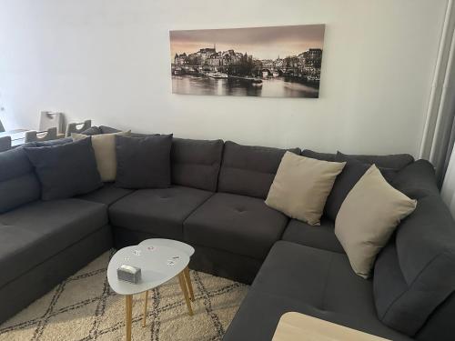 a living room with a gray couch and a table at Juga lux apartment in Fontana