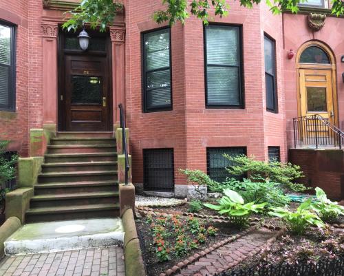 a brick house with a staircase leading to the door at Fenway Park Brownstone in Boston