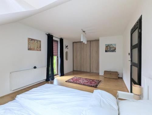 a bedroom with a white bed and a large room with at Ostań i Odpocznij Podzamcze in Podzamcze