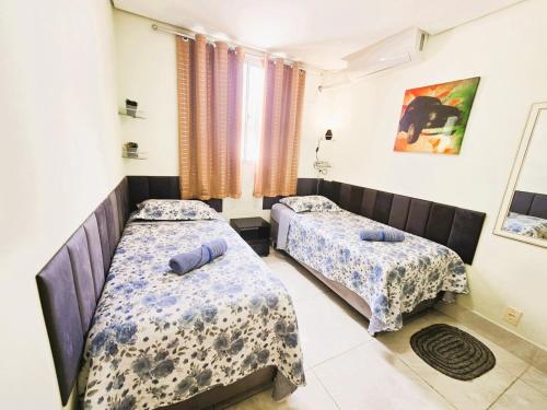 a bedroom with two beds and a window at Apto Completo próximo Aeroporto e Shopping in Várzea Grande