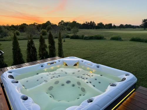 a hot tub on a deck with a view of a field at Green Field Villa in Kuressaare