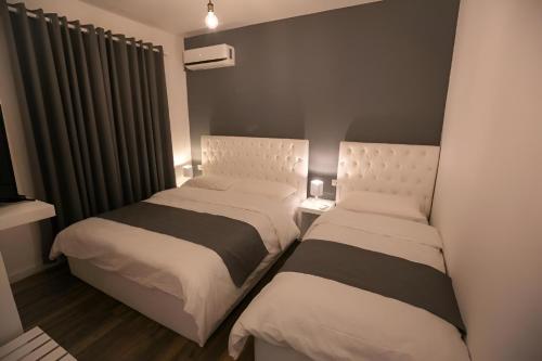 two beds in a small room withskirts at Hotel Sidi in Tirana