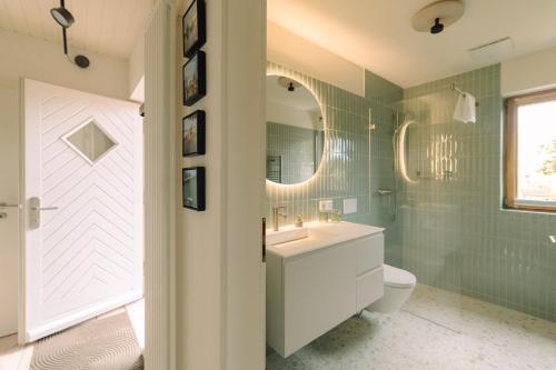 a bathroom with a sink and a toilet and a mirror at Eldehaus Plau am See klimatisiert in Plau am See