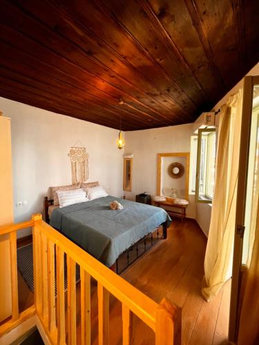 a bedroom with a bed with a wooden ceiling at Happiness skopelos in Glossa