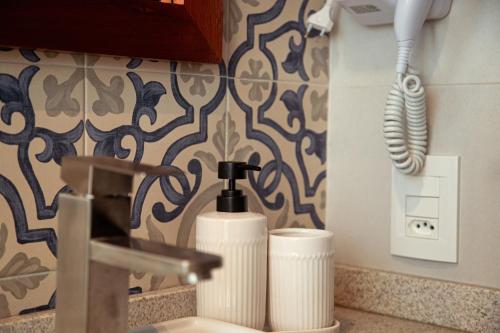 a sink with a soap dispenser and a toothbrush at Pousada e Restaurante Del Miro in Nova Pádua
