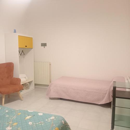 a bedroom with two beds and a chair and a desk at La Perla sul Trasimeno in San Feliciano