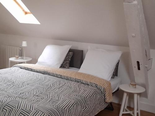 a bedroom with a bed and two white pillows at Quiétude au Bord de Loire. in Orléans