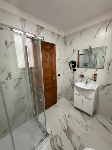 a marble bathroom with a shower and a sink at Holmann Haus in Olbia