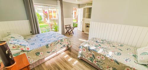 a bedroom with two beds and a table and a window at Inaki Uhi Hotel in Hanga Roa