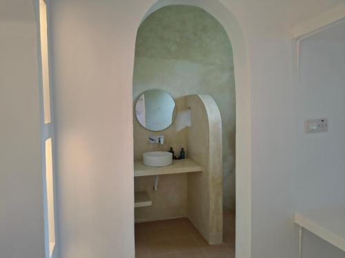 a bathroom with a sink and a mirror at ROHO-Residence in Nungwi