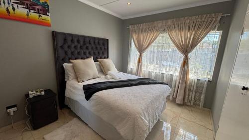 a bedroom with a large bed and a window at Bella Vista in Edenvale
