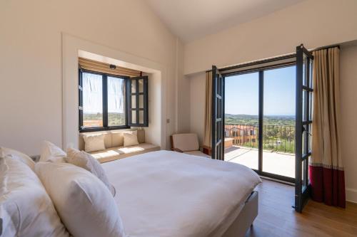 a bedroom with a large bed and a large window at Viento Villa in Çeşme