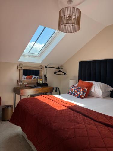 a bedroom with a bed with a window and a desk at The courtyard bar, kitchen, rooms in Falkirk