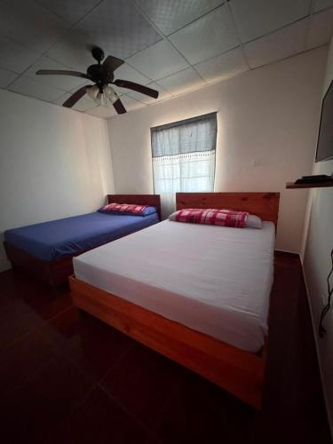 a bedroom with two beds and a ceiling fan at El Rincon De Lupe in San Carlos