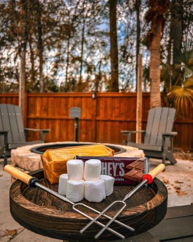 a wooden table with a tray of marshmallows and bats at The Summer House - Private Pool Firepit in Jacksonville