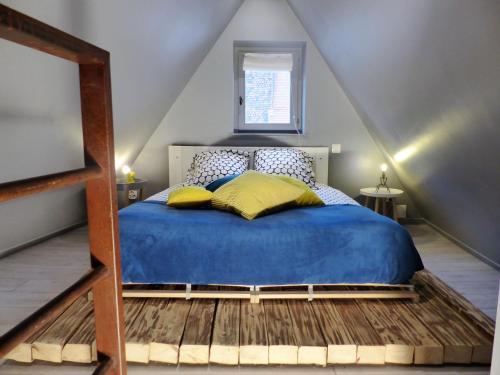 a bedroom with a blue bed in a attic at La Venise bleue in Colmar