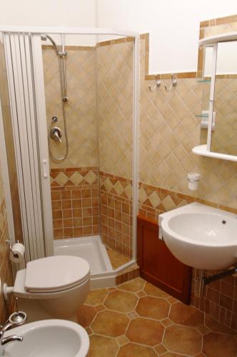 a bathroom with a toilet and a sink and a shower at Bari Sardo Le More Suite 3 in Bari Sardo