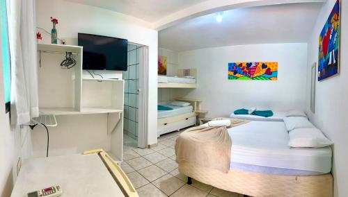 a small room with two beds and a tv at Pousada Brasil Natal in Natal