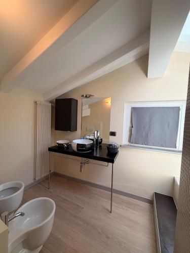 a bathroom with a sink and a desk with a window at Casa Cocci in Aosta